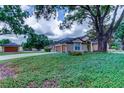 Charming single-story home featuring a well-manicured lawn and a detached garage at 15302 Lake Maurine Dr, Odessa, FL 33556