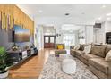 Bright, open-concept living room with hardwood floors, a large sofa, and eye-catching decorative wall accents at 2222 Longmore Cir, Valrico, FL 33596