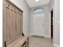 Inviting foyer with tiled floor, coat rack and bench seating upon entry at 2823 Banyan Hill Ln, Land O Lakes, FL 34639