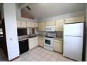 Bright kitchen with white appliances, tile floors, laminate countertops, and ample cabinet space at 4214 Longfellow Dr, Plant City, FL 33566
