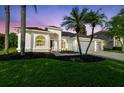 Charming home featuring a three-car garage, manicured lawn, and mature palm trees at 4227 Sandy Shores Dr, Lutz, FL 33558