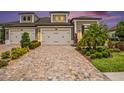 Beautiful home exterior with brick driveway, manicured landscaping, and a two-car garage at 4329 Barletta Ct, Wesley Chapel, FL 33543