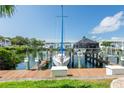 Dock view with sailboat and covered powerboat with waterfront condo in the background at 5075 Starfish Se Dr # A, St Petersburg, FL 33705