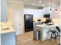 Modern kitchen featuring white cabinets, stainless steel appliances, and a breakfast bar at 514 S Orleans Ave # 4, Tampa, FL 33606