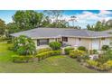Charming single-story home featuring lush landscaping and attached two-car garage at 5456 Fairway Bend Dr, Sarasota, FL 34243