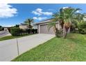 Spacious two-car garage with a long driveway, complemented by lush landscaping and sunny blue skies at 5914 Goldenbark Pl, Lithia, FL 33547