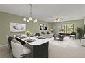Bright open-concept living and dining room with neutral colors and sliding glass doors to lanai at 5920 80Th N St # 103, St Petersburg, FL 33709