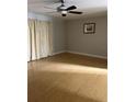Bright living room featuring hardwood floors, ceiling fan and light-filled windows at 7210 N Manhattan Ave # 1311, Tampa, FL 33614