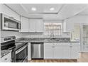 Modern kitchen features stainless steel appliances, granite countertops, and white cabinets at 7627 Deleon Ct, Tampa, FL 33615