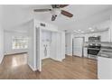 Open kitchen features stainless steel appliances and leads to the dining area with laminate flooring at 7627 Deleon Ct, Tampa, FL 33615