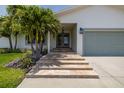Welcoming front entrance with stone steps, glass double doors, and lush landscaping leading to an attached garage at 817 Eagle Ln, Apollo Beach, FL 33572