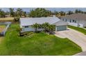Beautifully landscaped single-story home with a well-manicured lawn, a metal roof, and a large driveway at 817 Eagle Ln, Apollo Beach, FL 33572