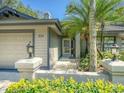 Close up view of a beautiful home entrance with decorative lighting and professional landscaping at 934 Lucas Ln, Oldsmar, FL 34677