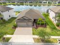 Aerial view of a beautiful home with lush landscaping and a peaceful lake in the neighborhood at 12352 Crestridge Loop, New Port Richey, FL 34655