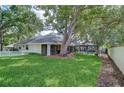 Spacious backyard featuring lush green grass, mature trees, a screened-in pool, and a white picket fence at 124 Barrington Dr, Brandon, FL 33511