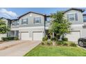 Charming townhome featuring a gray exterior, white garage doors, and well-maintained landscaping at 1594 Cassius St, Lutz, FL 33549
