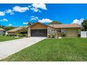 Beautiful one-story home featuring a long driveway, a two-car garage, stone accents, and a well-maintained lawn at 2436 Covington Ave, Spring Hill, FL 34608