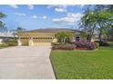 Charming yellow single-story home with a well-manicured lawn and three-car garage at 2712 Clubhouse Dr, Plant City, FL 33566