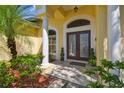 Elegant front entrance featuring double doors, stone flooring, and manicured shrubbery at 2712 Clubhouse Dr, Plant City, FL 33566