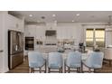 Bright, spacious kitchen features stainless steel appliances, a large island with seating, and elegant white cabinetry at 29837 Imperati Blvd, Wesley Chapel, FL 33543