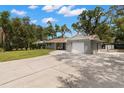 Charming single-story home with a brick facade, well-maintained lawn, a long driveway and attached one car garage at 3119 W North St, Tampa, FL 33614