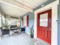 Welcoming front porch with outdoor seating, plants, and a bright red front door for a pop of color at 3213 E Genesee St, Tampa, FL 33610