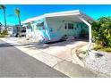 Inviting mobile home with a covered carport, lush landscaping, and a cozy, welcoming exterior at 34483 Cactus N Dr, Pinellas Park, FL 33781