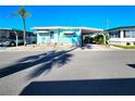 Charming home boasts a vibrant aqua exterior with an attached carport and meticulous landscaping, creating a welcoming ambiance at 34483 Cactus N Dr, Pinellas Park, FL 33781