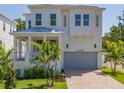 Beautiful two-story home featuring white siding, a covered porch, and a two-car garage at 509 Buckingham E Ave, Oldsmar, FL 34677
