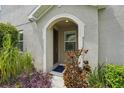 Charming entryway with arched doorway and lush landscaping at 513 Harbor Springs Dr, Palm Harbor, FL 34683