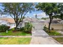 Beautiful home with a well-manicured lawn, mature trees, and a long driveway leading to the garage at 5628 Terrain De Golf Dr, Lutz, FL 33558