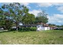 Well-kept single-story home featuring mature trees, a manicured lawn, and a white picket fence at 5698 26Th N Ave, St Petersburg, FL 33710