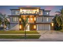 Beautiful three-story home with balconies, modern lighting, a two-car garage, and a well-maintained lawn at 5964 Bayview S Cir, St Petersburg, FL 33707