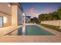 View of backyard pool with travertine pavers, adjacent to the house, with privacy landscaping and fence at 5964 Bayview S Cir, St Petersburg, FL 33707