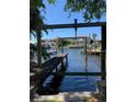 Private dock on the water with a boat lift and view of the neighborhood homes at 600 Banana St, Tarpon Springs, FL 34689