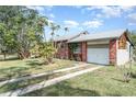 Cozy home showcasing a brick exterior, metal roof, and a convenient driveway at 6118 Kracker Ave, Gibsonton, FL 33534