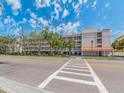 Condominium complex with multiple stories, private balconies, and mature trees along the street at 640 Bayway Blvd # 302, Clearwater Beach, FL 33767