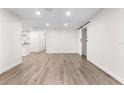 Bright living room featuring wood-look floors, recessed lights, and a modern sliding door at 6612 W Chelsea St, Tampa, FL 33634