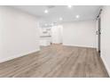 Bright living room featuring wood-look floors and recessed lights, connecting to the kitchen at 6612 W Chelsea St, Tampa, FL 33634