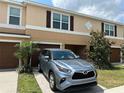 Tan townhouse showing the front door, garage, landscaping and a silver SUV at 7221 Sterling Point Ct, Gibsonton, FL 33534