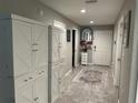 Hallway with tile floor and white storage cabinets at 7221 Sterling Point Ct, Gibsonton, FL 33534