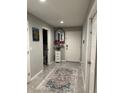 Hallway with tile floor, white door and vanity with mirror and flower at 7221 Sterling Point Ct, Gibsonton, FL 33534