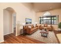 Living room with wood floors, ceiling fan, and windows, virtually staged with sofas and decor at 8812 Beeler Dr, Tampa, FL 33626