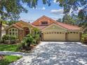 Charming home with a three car garage, mature landscaping and a clay tile roof at 10229 Waterside Oaks Dr, Tampa, FL 33647