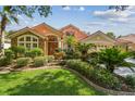 Charming home featuring mature landscaping, a clay tile roof, and a welcoming entrance at 10229 Waterside Oaks Dr, Tampa, FL 33647
