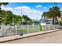 Charming home featuring a lush lawn, tropical landscaping, and white picket fence at 106 13Th Ave, St Pete Beach, FL 33706