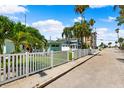 Lovely home featuring a white picket fence, tropical landscaping, and neighborhood street view at 106 13Th Ave, St Pete Beach, FL 33706