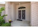 Close-up of the front door with decorative security doors and brick columns at 1142 Sweet Jasmine Dr, Trinity, FL 34655