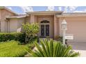 Inviting front porch with double doors, brick columns, and manicured landscaping at 1142 Sweet Jasmine Dr, Trinity, FL 34655