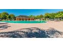 Large community pool with spacious brick patio, palm trees, and a clubhouse for resident enjoyment at 14614 Rannoch Moor Pl, Wimauma, FL 33598